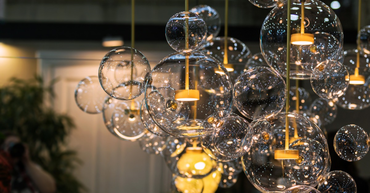 A close-up of a large chandelier with multiple glass bubbles and small lights on different levels inside a room.